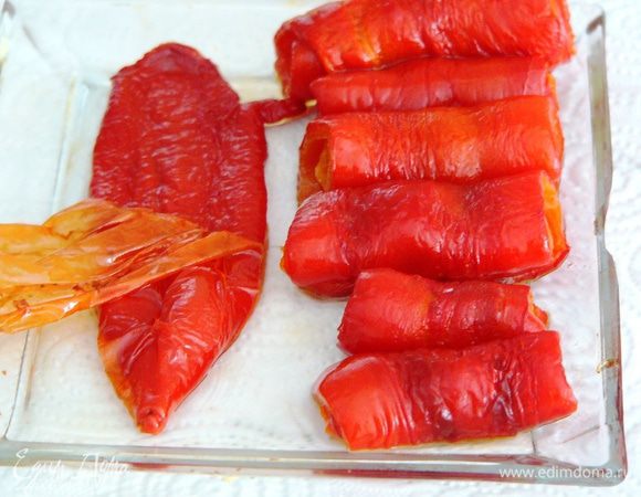 Теперь аккуратно снимаем кожицу с перца. Для удобства поедания и красивой подачи скручиваем дольки перца рулетиком. Готовые рулетики выкладываем на блюдо. 