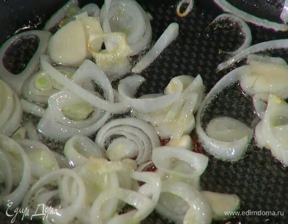 Разогреть в сковороде немного оливкового масла и выложить лук с чесноком.