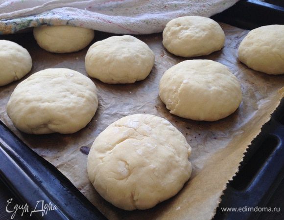 Отщипываем кусочек теста и формируем булочки. Выложить заготовки на противень, застеленный бумагой для выпечки, на приличном расстоянии друг от друга! Булочки увеличатся раза в два! Немного приплюснуть наши заготовки пальцами, накрыть полотенцем и оставить ещё на 30-45 минут в теплом месте.