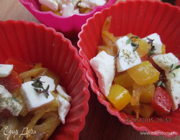 Перцы нарезаем кубиками, лук - полукольцами. Обжариваем на растительном масле до готовности, добавляем мед, зелень, соль и перец и
выкладываем на дно формочек вместе с кусочками творога. 

