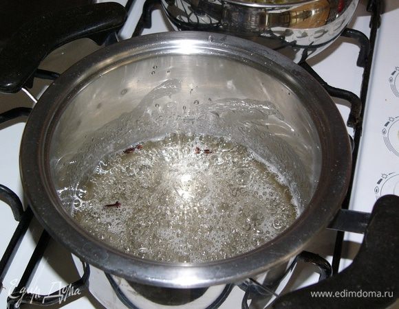 В другую кастрюлю влить 0,5 стакана воды, добавить сахар, закипятить и варить, помешивая, 10 минут. 