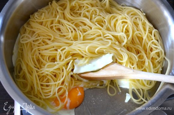 К этому времени должны быть готовы спагетти. Не забываем отлить немного воды от варки спагетти (чуть меньше стакана), сливаем спагетти и выкладываем сразу в сковороду с яйцами.
