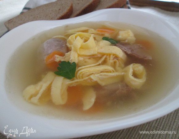 Разливаем бульон по тарелкам, добавляем кусочки мяса и яичную лапшу. Добавляем зелень и подаем.