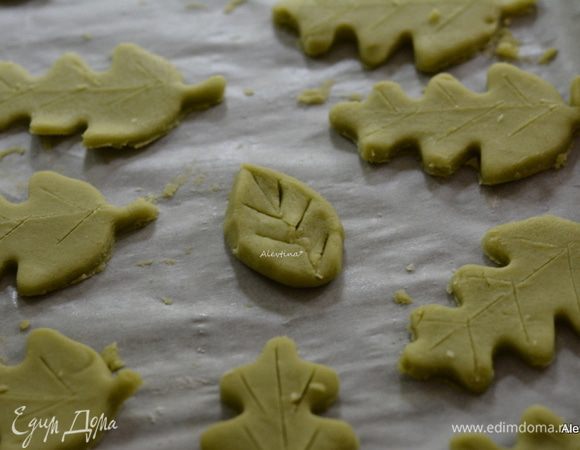 Если нет формочки для вырезания листьев, то можно отщипывать от теста по небольшому куску, формировать руками листочки. Как в центре фото. 
Тонким ножом нарисовать, слегка надавливая на лезвия, линии листика.
Также проделать потом со вторым противнем.
Затем ставим разрисованные листочки в разогретую духовку на 160С на 17-22 мин.