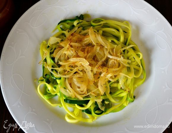 Теперь выложить овощи на тарелку слоями. Первым слоем выложить половину цукини. Сверху выложить половину лука.