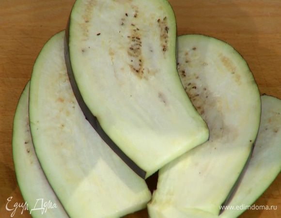 Баклажан нарезать вдоль не слишком толстыми пластинами, посолить и дать постоять.