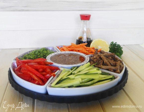 В чашу, в которой будем подавать блюдо, в центре устанавливаем соусник, по кругу выкладываем небольшими горками овощи и мясо. Подаем к столу. Каждый может взять себе в тарелку те составляющие, которые ему больше всего нравятся, или положить каждого ингредиента понемногу, заправить соусом и перемешать. Приятного аппетита!