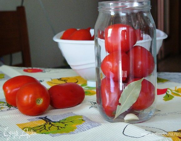 Помидоры и свежий острый перец помойте и обсушите. Подготовьте банки. На данное количество ингредиентов я взяла 4 литровые банки. Банки вымойте с содой. Этим можно ограничиться, но на всякий случай я их еще стерилизовала в духовке при 150°C 15 минут. В каждую банку положите лавровый лист, гвоздику, черный и душистый перец горошком, 2 зубчика чеснока. Очень сильный аромат дает укроп, так что, если есть, добавьте его тоже. Плотно уложите в банки помидоры, добавив по 1 стручку острого перца.