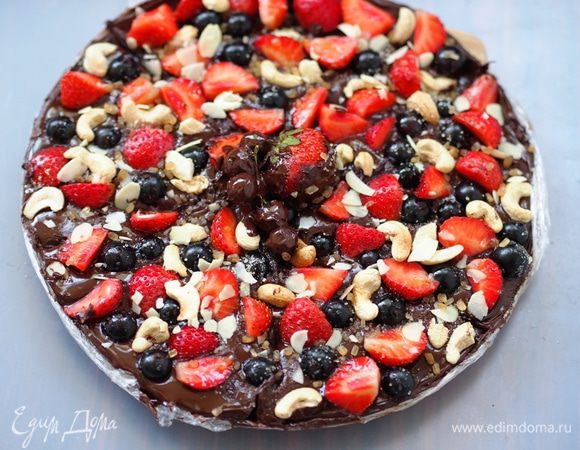 Украсить еще мягкую шоколадную пиццу, вдавливая слегка руками в шоколад, клубникой, черной смородиной, орехами и посыпать сверху сахаром. Ягоды все же у нас кислые, а шоколад горький - для полной гармонии как раз и не хватает карамельной сладости тростникового сахара! Снова поставить "пиццу" в холодильник до полного застывания шоколада. У меня стояла около часа.