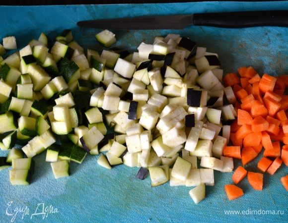 Подготовить первым делом овощи: вымыть цукини, баклажан и морковь (овощи берите не самые крупные). Морковь очистите и нарежьте небольшими кубиками. Цукини и баклажан также нарезать маленькими кубиками.