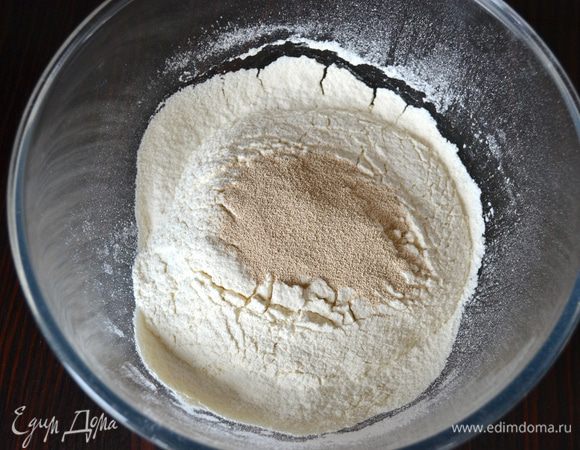 Просейте в миску муку и смешайте ее с дрожжами.