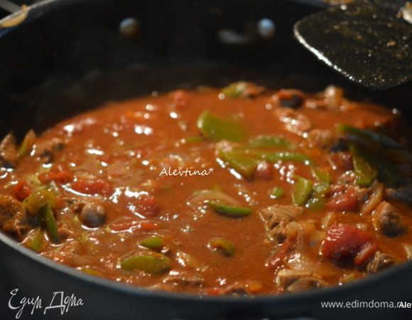 Вернуть говядину, добавить мясной бульон, томат, нарезанные кубиками в соку, томатный соус, все специи сухие, мед. Перемешать.