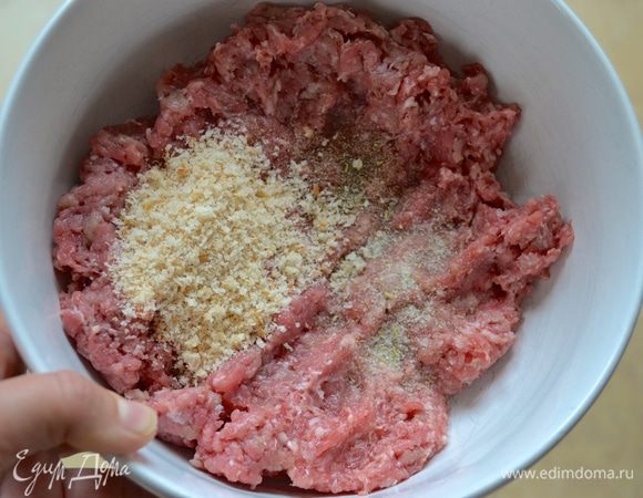 Теперь подготовьте фарш. Для этого лучше брать смешанный свино-говяжий фарш. Добавьте в него панировочные сухари, соль и перец (специи по вкусу). Перемешайте.