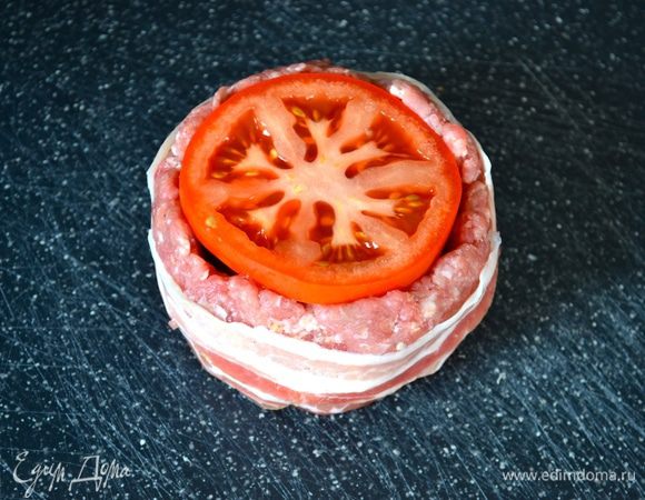 Помидоры нарежьте круглыми ломтиками и выложите поверх грибов. 