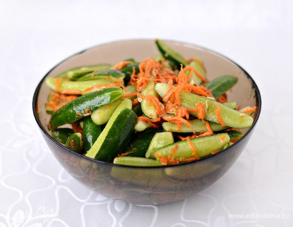 В глубокой емкости смешать морковь, огурцы, измельченный чеснок (количество чеснока варьируйте на свой вкус, с таким кол-м как у меня огурчики получаются в меру острые), растительное масло, сахар, соль, уксус и приправу для моркови по-корейски (1/3 пакетика).
