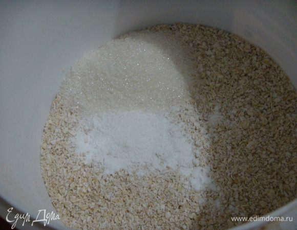 К овсяной муке добавляем разрыхлитель и сахар. Перемешиваем.