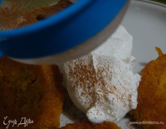 Выложить оладьи на тарелку, положить ложку сливок, сверху присыпать молотой корицей.