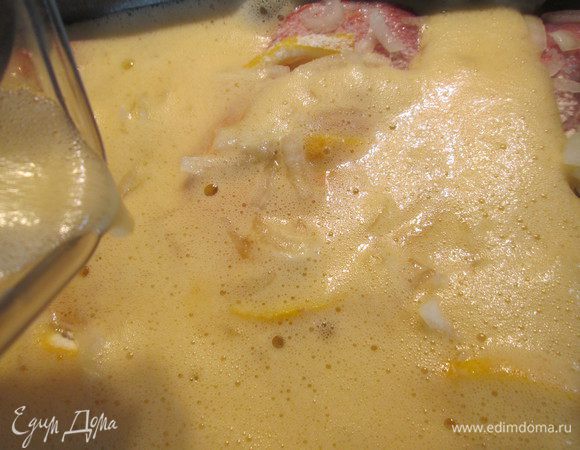 Засыпаем поверх муки лук и заливаем взбитой в блендере смесью из яиц, чеснока и вина. 