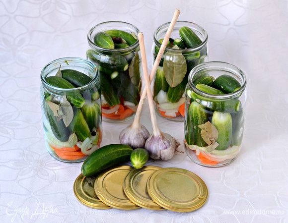 На дно стерилизованных банок уложить порезанные кольцами морковь и лук, лавровый лист, перец горошком. Уложить огурцы.

Залить маринадом:
В воду (4 л.) всыпать соль (4 ст. л.), сахар (9 ст. л.). Вскипятить. Убрать с огня. Дать немного остыть, примерно до 80-70 гр., влить 6 ст. л. уксусной эссенции (70%). Остудить до комнатной температуры. Залить огурцы маринадом.
Пропорции ингредиентов маринада даны на 4 литра воды. 
