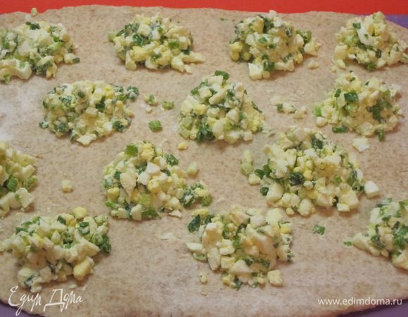 Разложить начинку на пласт теста небольшими горочками.