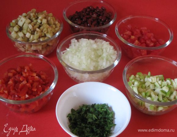 Лук очистить, нарезать мелкими кубиками. Перец вымыть, нарезать кубиками. Кабачок очистить, нарезать кубиками. Помидор надрезать, ошпарить кипятком, затем залить холодной водой, снять кожицу, нарезать кубиками. Открыть баночку фасоли, слить маринад. Зелень мелко нарезать.