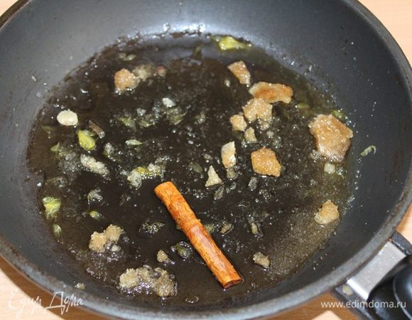 В сковороду выжать апельсиновый сок, добавить сахар и палочку корицы. Поставить на умеренный огонь.
