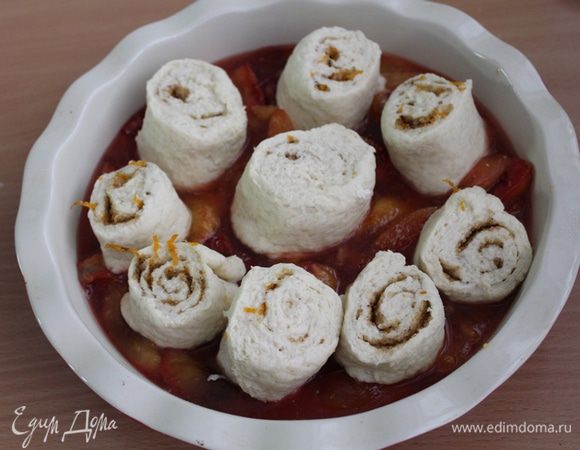 Скатать в рулет и острым ножом разрезать. Уложить спиральки из теста в форму на сливы.