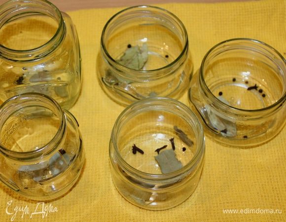 На дно стерилизованных баночек выложить лавровый лист по листочку, по 2 гвоздички, душистый перец по 5 шт.