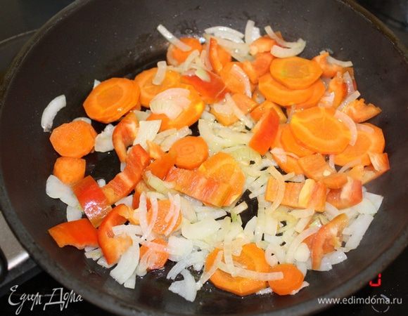 Разогреть сковороду с оливковым маслом. Обжарить лук до прозрачности 5-7 минут, помешивая. Добавить морковь, нарезанную кружочками, и перец, нарезанный кубиками. Готовить 5 минут, помешивая. 