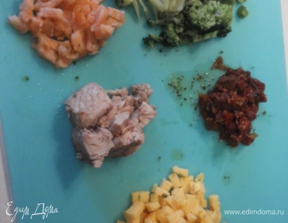 Тем временем готовим начинку. В оставшуюся молочно-яичную смесь добавляем мелко порезанные: брокколи, семгу, вяленые помидоры, размятый вилочкой тунец и порезанный мелким кубиком сыр. Хорошенько перемешиваем.