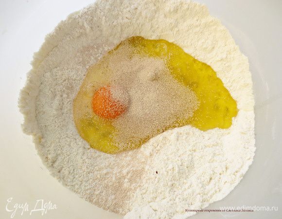 Сделать в середине углубление и добавить масло, яйцо, дрожжи. В оригинале рецепта яйцо не добавляют и масло используют сливочное. Его нарезают на кубики и добавляют в муку. Вы можете сделать как у меня или иначе.