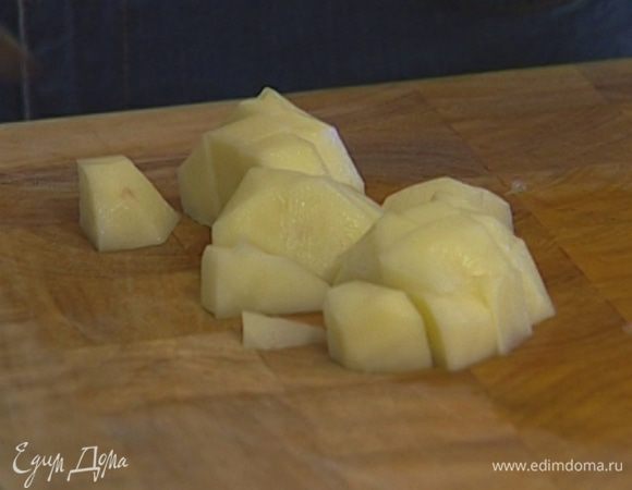 Картофель почистить, мелко порезать, добавить в кастрюлю с луком и чесноком и немного прогреть, чтобы он пропитался маслом.