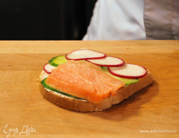 Тонко нарезать лосось и выложить на бутерброд.