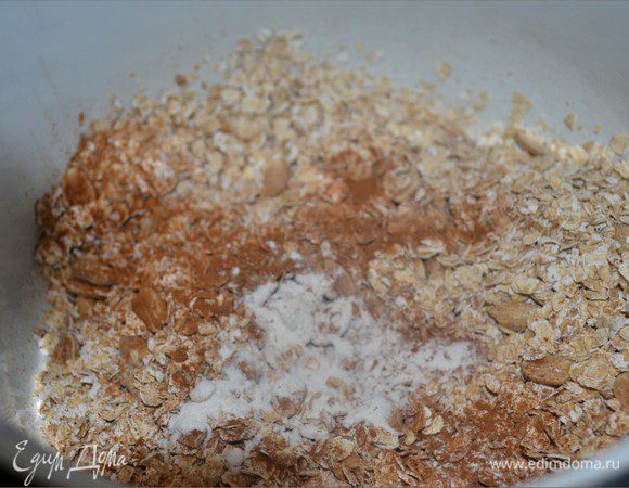 Тем временем займемся сухой смесью. В миске смешиваем геркулес, разрыхлитель и половину арахиса. Добавляем оставшуюся корицу.
