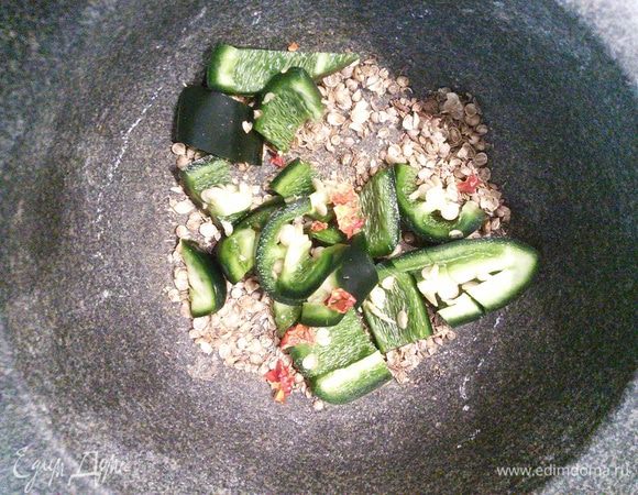 Теперь займемся арахисовой пастой. Кориандр и тмин нужно размолоть в ступке. Добавьте мелко нарезанный чили вместе с семенами и разомните в кашицу. У меня халапеньо и совсем не острый, вы регулируйте остроту соуса на свой вкус. Добавьте смесь азиатских специй. 