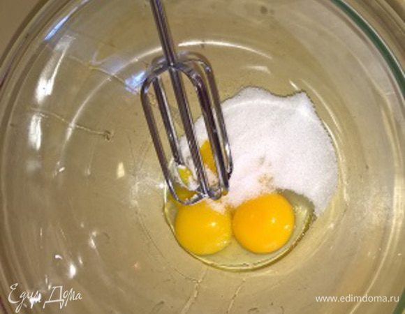 Яичные желтки взбиваем с сахаром до однородности. Затем соединяем их со сметаной, солью, сгущённым молоком и 2/3 порции орехов, тщательно перемешиваем.  
В отдельной сухой посуде взбиваем охлажденные белки в легкую пену. 