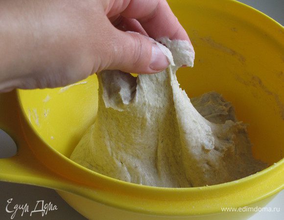 Добавить теплую воду и замесить тесто. Когда тесто станет однородным, добавить оливковое масло и месить еще несколько минут. Тесто получается липким, но муку лучше не добавлять. Накрыть тесто полотенцем и поставить в теплое место для подхода часа на полтора.