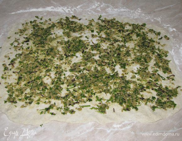 На тесто выложить топенаду и с помощью кулинарной лопатки равномерно распределить ее по пласту теста.