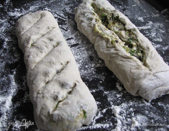 Аккуратно свернуть тесто в рулет. Разрезать на две части, края разрезов подвернуть и выложить на присыпанный мукой противень. Сделать на хлебе один большой разрез, немного раскрыв его или несколько насечек наискосок, как на батоне. Поставить багеты в духовку разогретую до 230 град. На нижнюю полку поставить емкость, в которую залить один стакан воды. Выпекать до золотистой корочки.