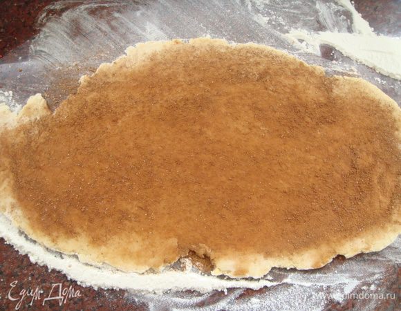 Раскатать часть теста в пласт. 2 ст ложки корицы смешать с 1 ст ложкой сахара, выложить на пласт теста и ладонью распределить равномерно по поверхности.