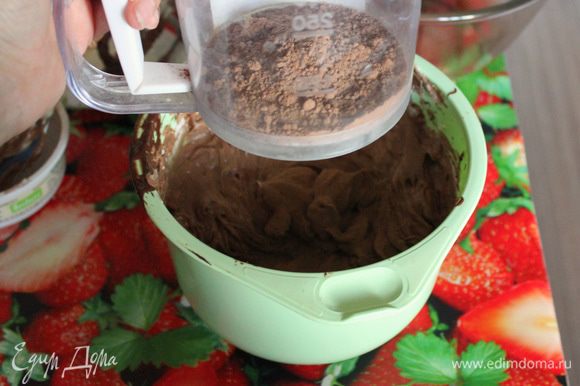 Вручную с помощью мягкой лопатки примешайте просеянную муку и какао порошок.