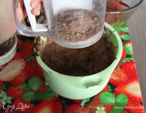 Вручную с помощью мягкой лопатки примешайте просеянную муку и какао порошок.
