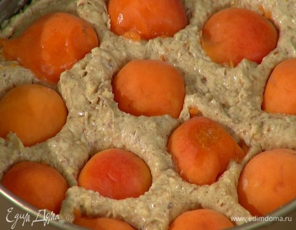 Абрикосы разделить пополам и, удалив косточки, поместить на тесто срезом вниз, слегка утапливая их.