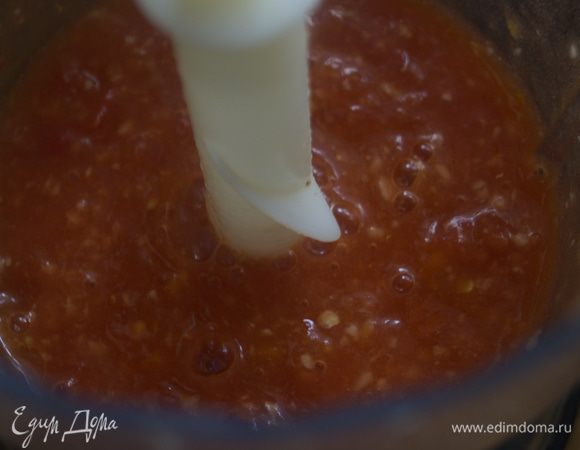 Помидоры нарезать дольками и пробить в блендере до состояния пюре. Чеснок пропустить через пресс, петрушку мелко порубить.