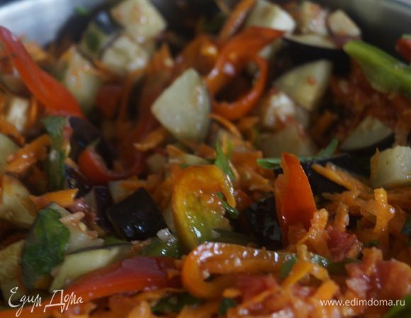 Выложить все овощи и зелень в большую кастрюлю, перемешать и залить маринадом, поставить на огонь. Готовить 40-45 минут, под закрытой крышкой, иногда помешивая.