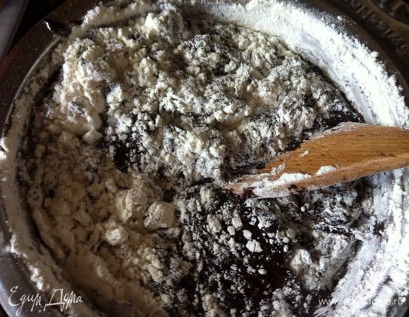 Вернуть на маленький огонь быстро ввести соду, сок половинки лимона, просеянную с какао муку и заварить тесто 3-4 минуты.