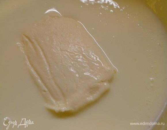 Кефир подогреть в микроволновой печи, вылить в чашку, где будем замешивать тесто. Туда же добавить творожок. Перемешать венчиком до однородности.