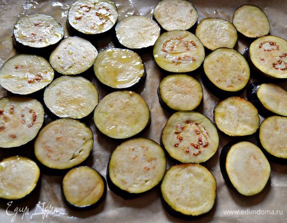 Нарежьте тонкими ломтиками баклажаны, посолите, дайте постоять 15 мин. Затем нужно промыть баклажаны холодной водой, промокнуть бумажными полотенцами, перемешать с 1 ст л оливкового масла и выложить на застеленный пекарской бумагой противень. Поставьте запекаться при 200г на 15-20 мин.
