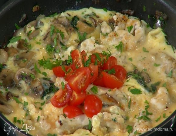 На готовый омлет выложить помидоры и посыпать петрушкой.