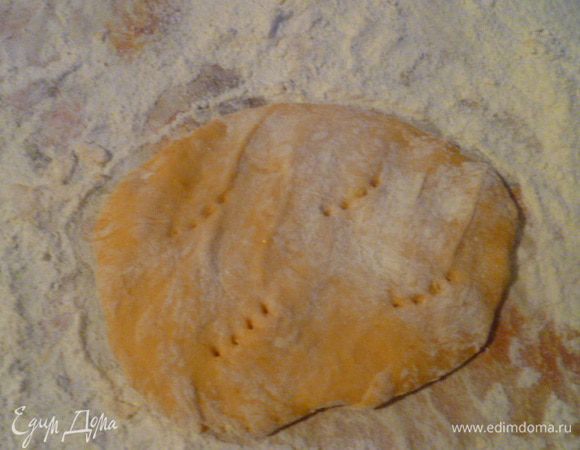 Затем беру липкий кусок и слегка обваливаю в муке, затем расплющиваю, формируя лепешку нужного мне размера.
Натыкаю вилкой.